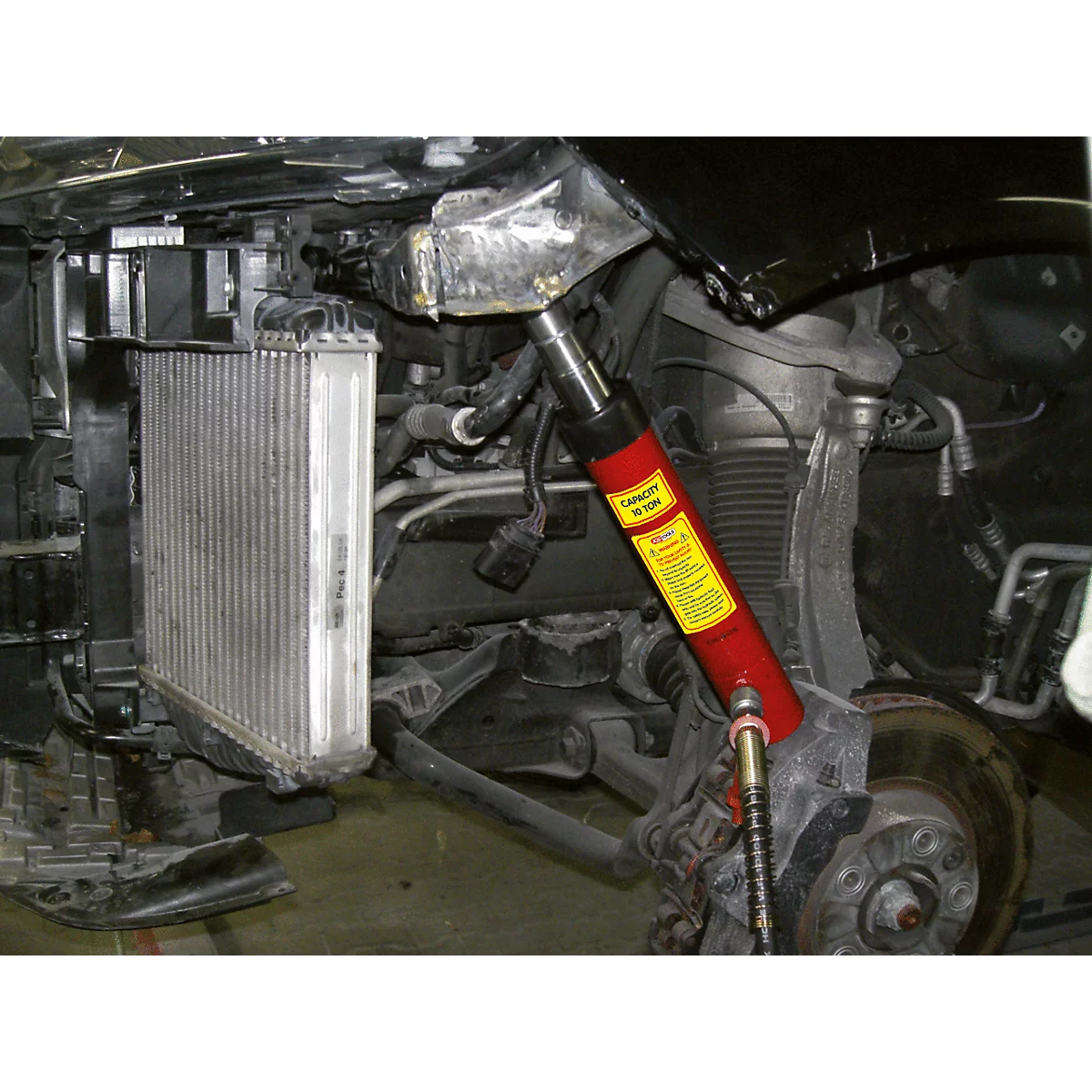 Ansicht eines beschädigten Fahrzeugs, ein Wagenheber hebt das Rad an.